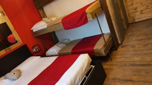 two bunk beds in a room with red walls at MadeBoutique Rooms in Madesimo