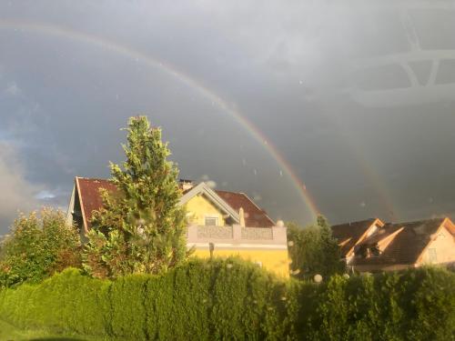 a rainbow in the sky over a house at Ferienwohnung Wittenburg in Hermagor