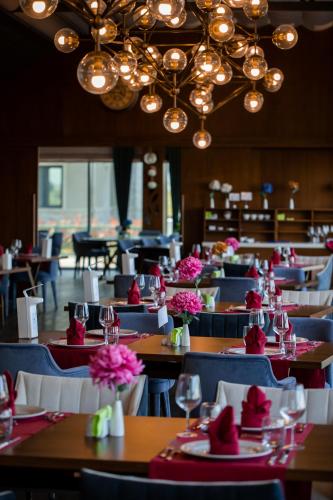 a restaurant with tables and chairs with flowers on them at Dreamland Golf Hotel Baku in Baku