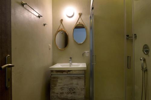 a bathroom with a sink and two mirrors on the wall at Locandiera in Corfu Town