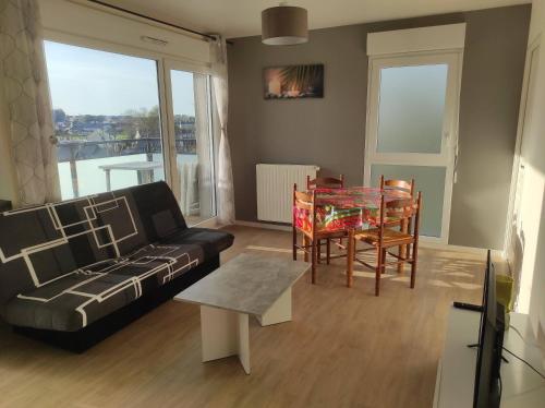 ein Wohnzimmer mit einem Sofa und einem Tisch in der Unterkunft t2 lumineux avec balcon in Saint-Malo