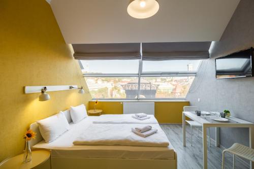 a small room with a bed and a window at Opera Passage Hotel & Apartments in Lviv