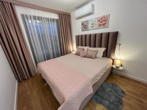 a bedroom with a large bed and a window at Corall apartment Bar in Bar