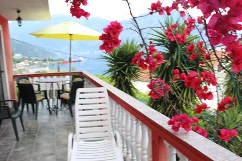 a balcony with a table and chairs and red flowers at Apartments Mijuskovic in Donji Morinj