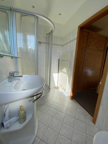 a white bathroom with a sink and a shower at App 2 in List