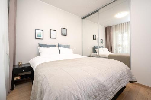 a bedroom with a large white bed and a mirror at Fabulous Location Apartments Deluxe in Tallinn
