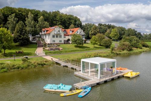 a dock with boats on the water in front of a house at Lakeside Resort Michaela in Antrifttal