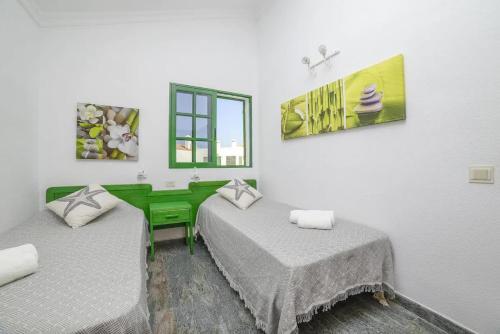una camera con due letti e una finestra di El Sueño - Appartamento fronte spiaggia vista mare a Cotillo