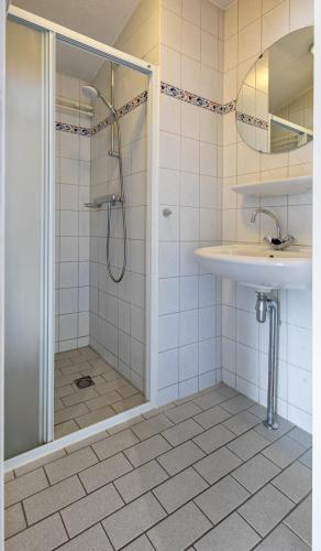 a bathroom with a shower and a sink at Appartementencomplex Motel Texel in De Koog
