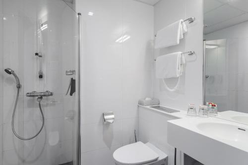 a bathroom with a shower and a toilet and a sink at Original Sokos Hotel Albert in Helsinki
