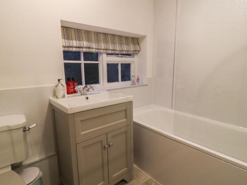 a bathroom with a sink and a bath tub at Jenny's Cottage in Northallerton