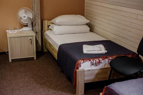 リヴィウにあるGuest House "Arkhistratyg"のベッド1台と椅子1脚が備わる客室です。