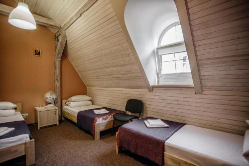 リヴィウにあるGuest House "Arkhistratyg"のベッド2台と窓が備わる屋根裏部屋です。
