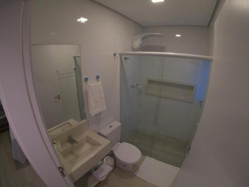 a bathroom with a shower and a toilet and a sink at Hotel e Pousada Magic in Penha