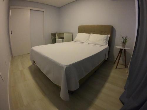 a bedroom with a large bed with white sheets at Hotel e Pousada Magic in Penha