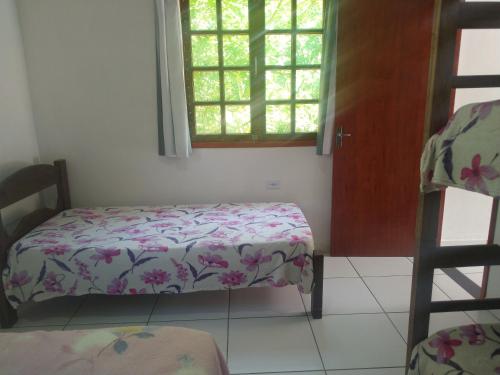 a small room with a bed and a window at Chalés Bela Vista in Paraty