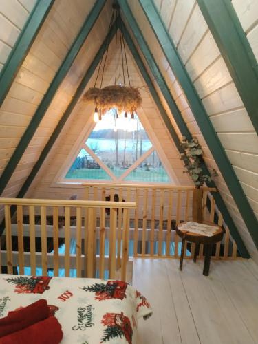 a room with a bed and a window in a attic at Aframe Shanti DreamDim in Svityazʼ