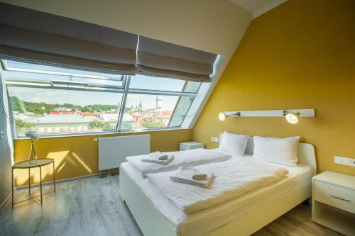 a bedroom with a large bed and a large window at Opera Passage Hotel & Apartments in Lviv