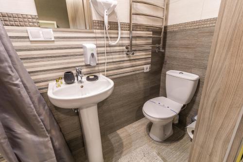 a bathroom with a toilet and a sink at Opera Passage Hotel & Apartments in Lviv
