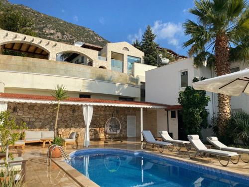 a villa with a swimming pool in front of a house at Villa Sezen in Kalkan