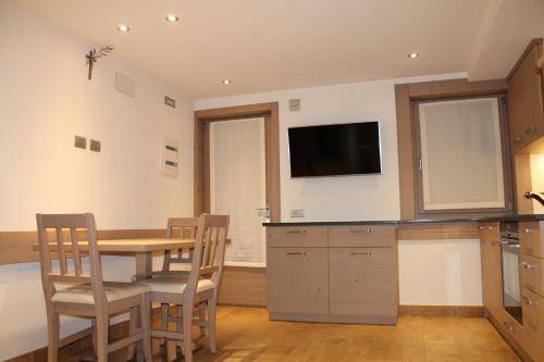a kitchen with a table and chairs and a tv at Pedrin's House in Livigno