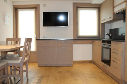 eine Küche mit einem Tisch und einem TV an der Wand in der Unterkunft Pedrin's House in Livigno