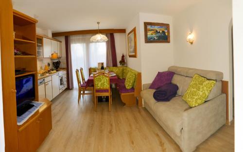 a living room with a couch and a table at Villa Artic Apartments in Campitello di Fassa