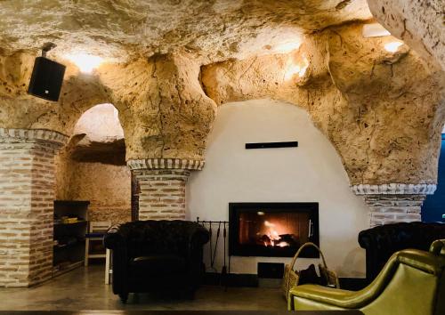 una sala de estar con chimenea en una cueva en Casa cueva El Nido Casa Rural, en Casas de los Teatinos