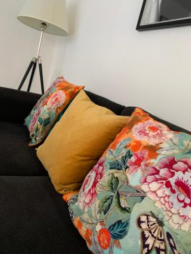 a pillow sitting on a couch with a flower patterned blanket at Causewayside in Edinburgh