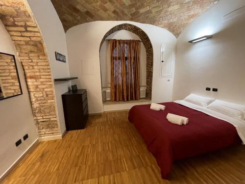 sypialnia z czerwonym łóżkiem i 2 ręcznikami w obiekcie Heart of San Lorenzo - La casa particular w Rzymie