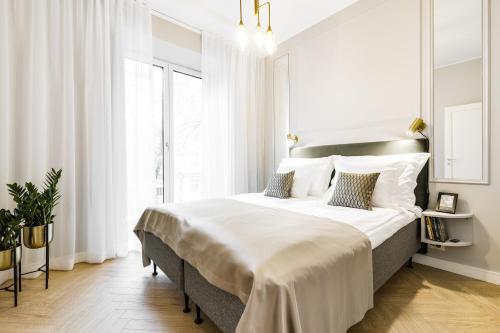 a white bedroom with a large bed with white pillows at Bob W Tallinn City Centre - Ambassador in Tallinn
