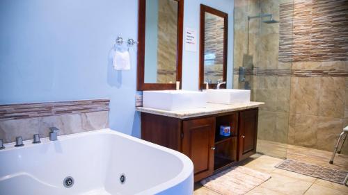 a bathroom with two sinks and a tub and a shower at Marantha Villa in Discovery Bay
