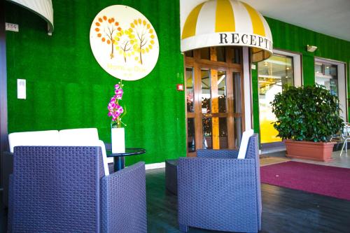 a restaurant with purple chairs and a green wall at Hotel Agli Olmi in San Biagio di Callalta