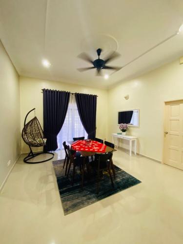 a dining room with a table and a ceiling fan at AYAHLONG BEACH GUESTHOUSE in Kampong Sura Masjid