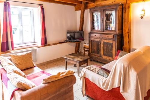 a living room with two couches and a tv at GITE AUTOMNE in Le Soulié
