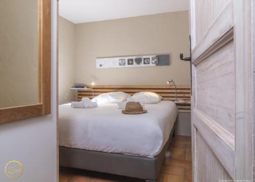 a bedroom with a bed with a hat on it at Les Garrigues de la Vallée des Baux in Paradou