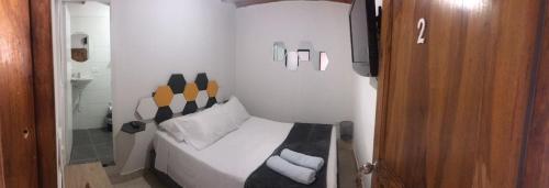 a small bedroom with a bed and a television at JARDIN SECRETO in Jardin