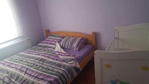 a small bed in a bedroom with a window at Apartman Ivanović 5 in Soko Banja