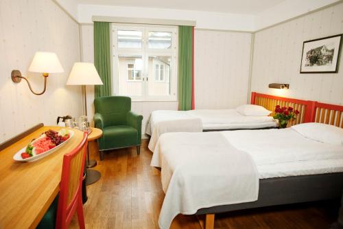 ストックホルムにあるSTF ホテル ジンケンスダムのベッド2台とテーブルが備わるホテルルームです。