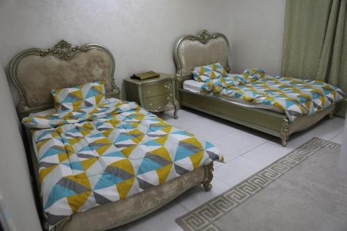 two beds sitting next to each other in a bedroom at Aljood Resort in Ras al Khaimah