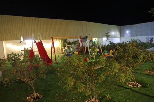 a playground in a yard at night with trees at Aljood Resort in Ras al Khaimah