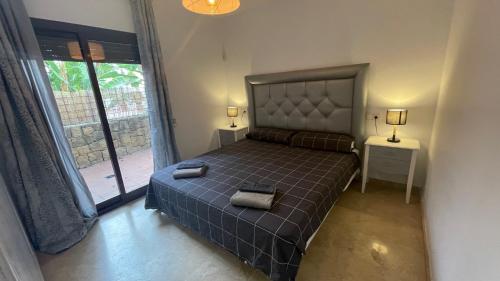 1 dormitorio con cama y ventana grande en Sierra Carzola, en Marbella