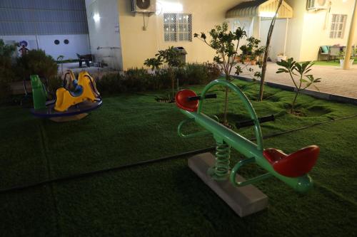 a playground with a slide in a yard at Aljood Resort in Ras al Khaimah