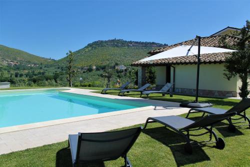 a swimming pool with chairs next to a house at LO SCRIGNO COUNTRY HOUSE in Coltodino