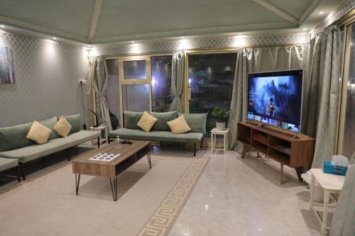 a living room with couches and a flat screen tv at Aljood Resort in Ras al Khaimah