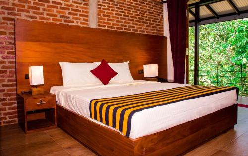 - une chambre avec un grand lit et une tête de lit en bois dans l'établissement Roshara Nalla, à Giriulla