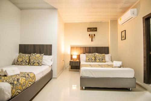 a hotel room with two beds and azeb sidx sidx sidx sidx sidx at Cienaguas Hotel in Ciénaga
