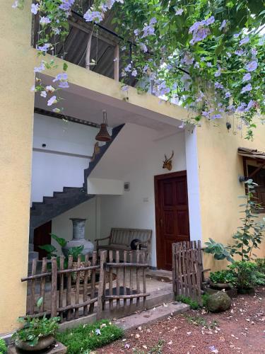 a house with a porch with two chairs and a staircase at Guruwaththa Eco Lodge in Hikkaduwa