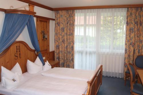 a bedroom with a large bed and a window at Landhotel Gasthof Huber in Merching