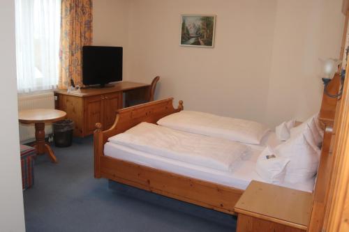 a bedroom with two twin beds and a television at Landhotel Gasthof Huber in Merching